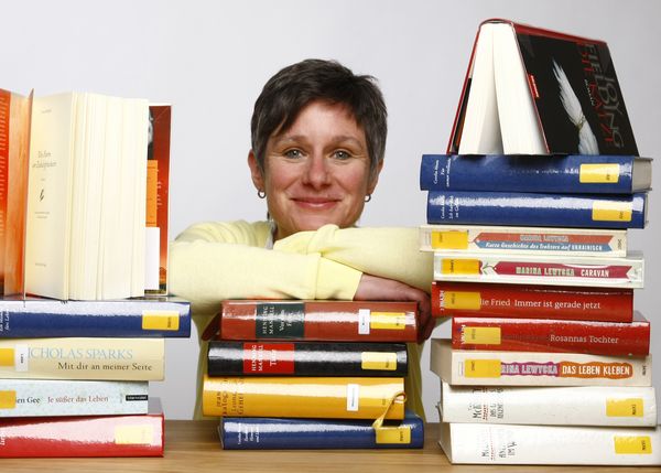Maria Klügel mit vielen Büchern um sich